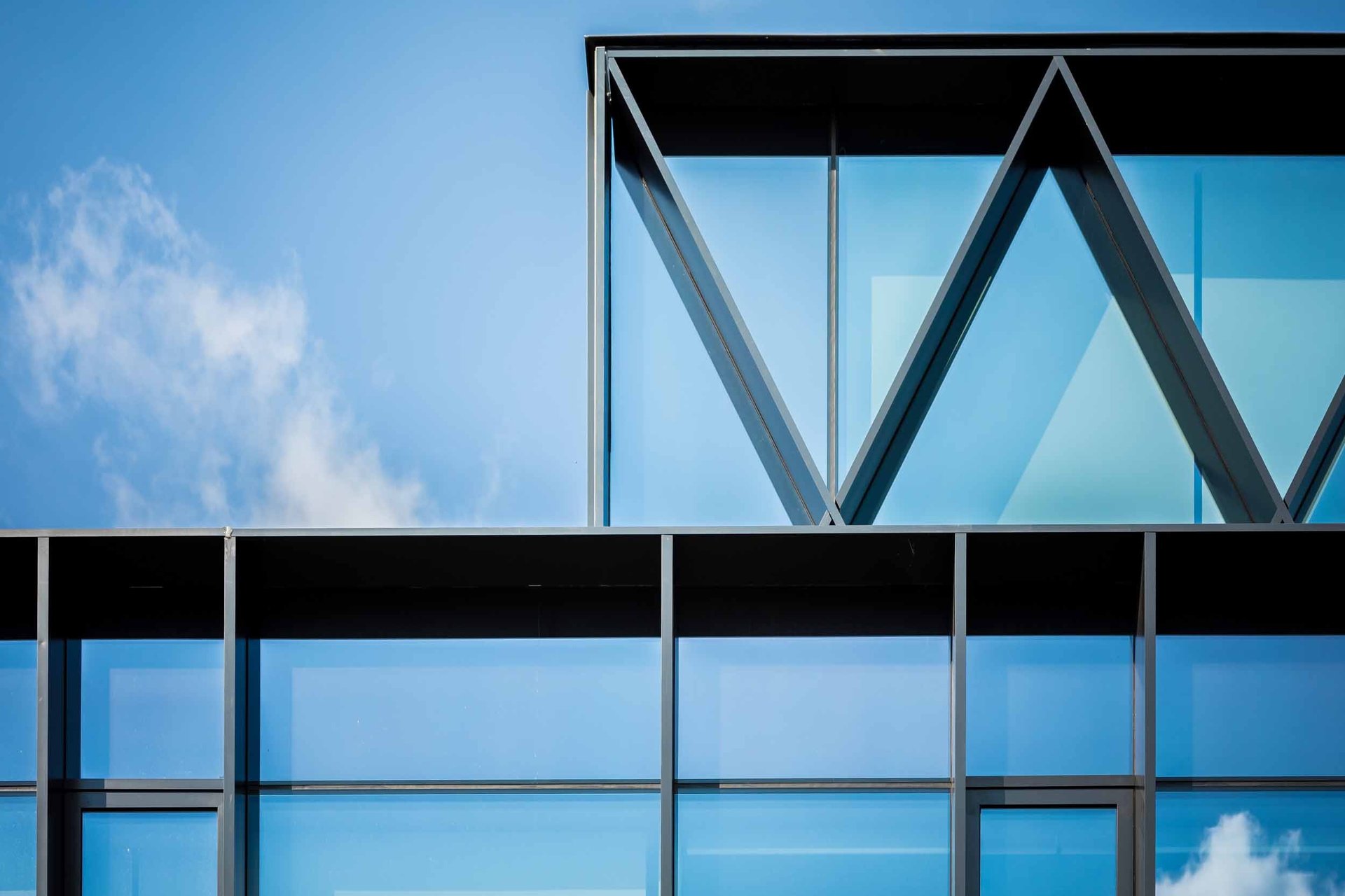 an abstract photo of a curved building with a blue sky in the background