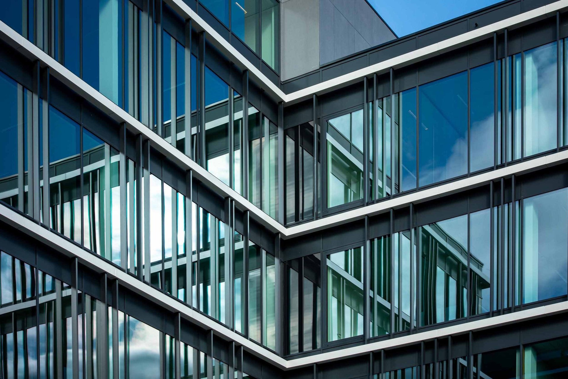 an abstract photo of a curved building with a blue sky in the background