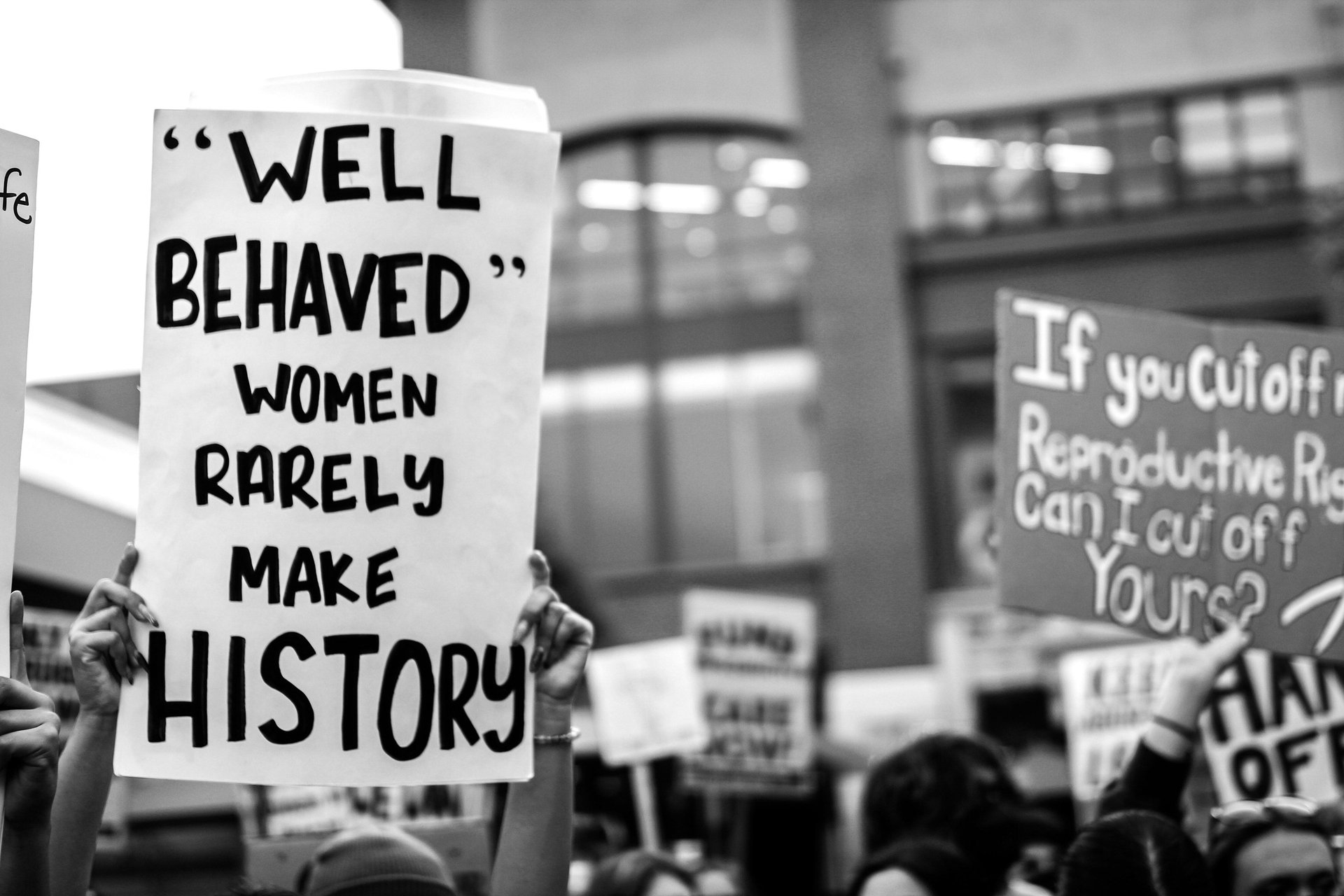 Silhouettes of seven women against a white background.