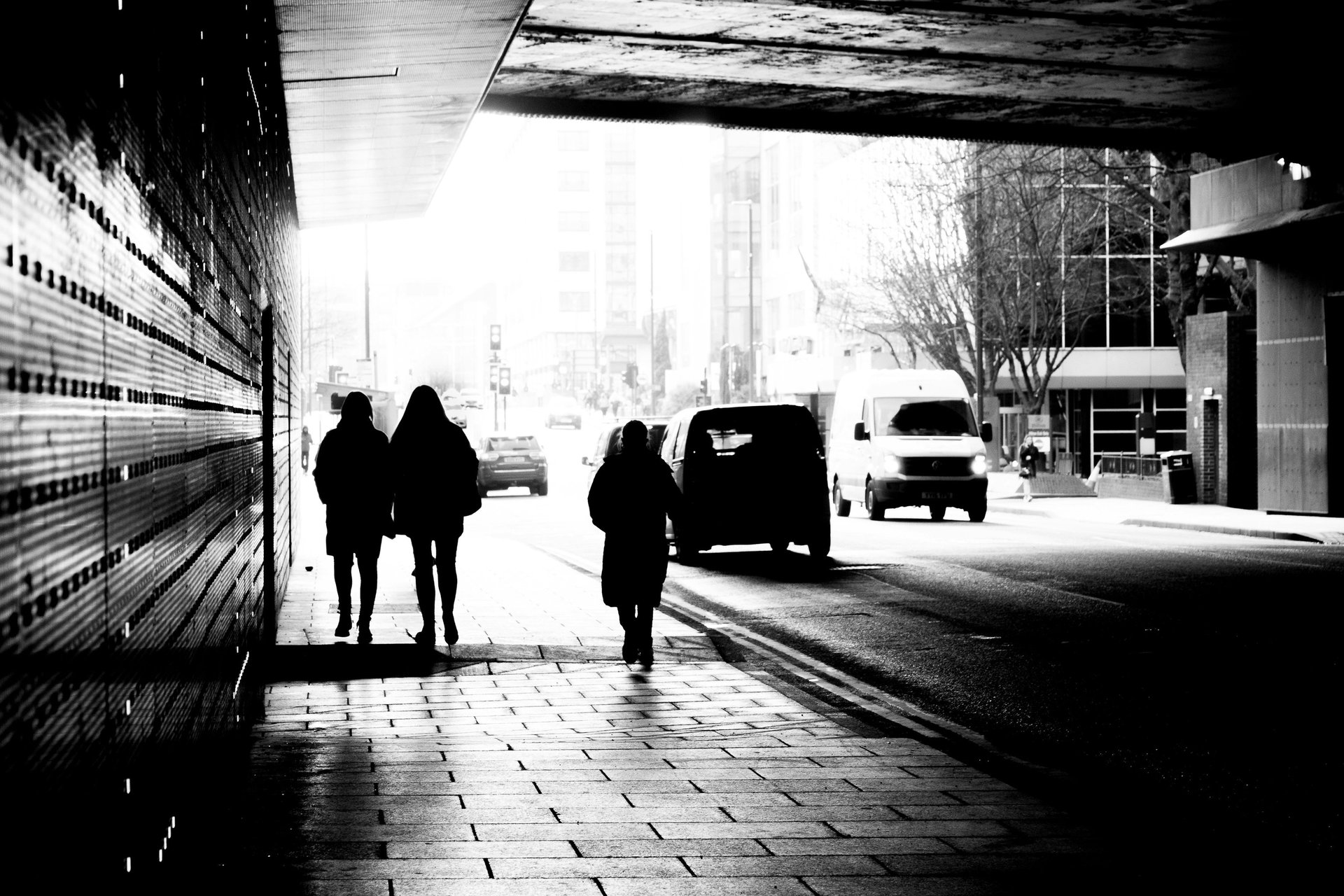 a black and white photo of a street lined with trees