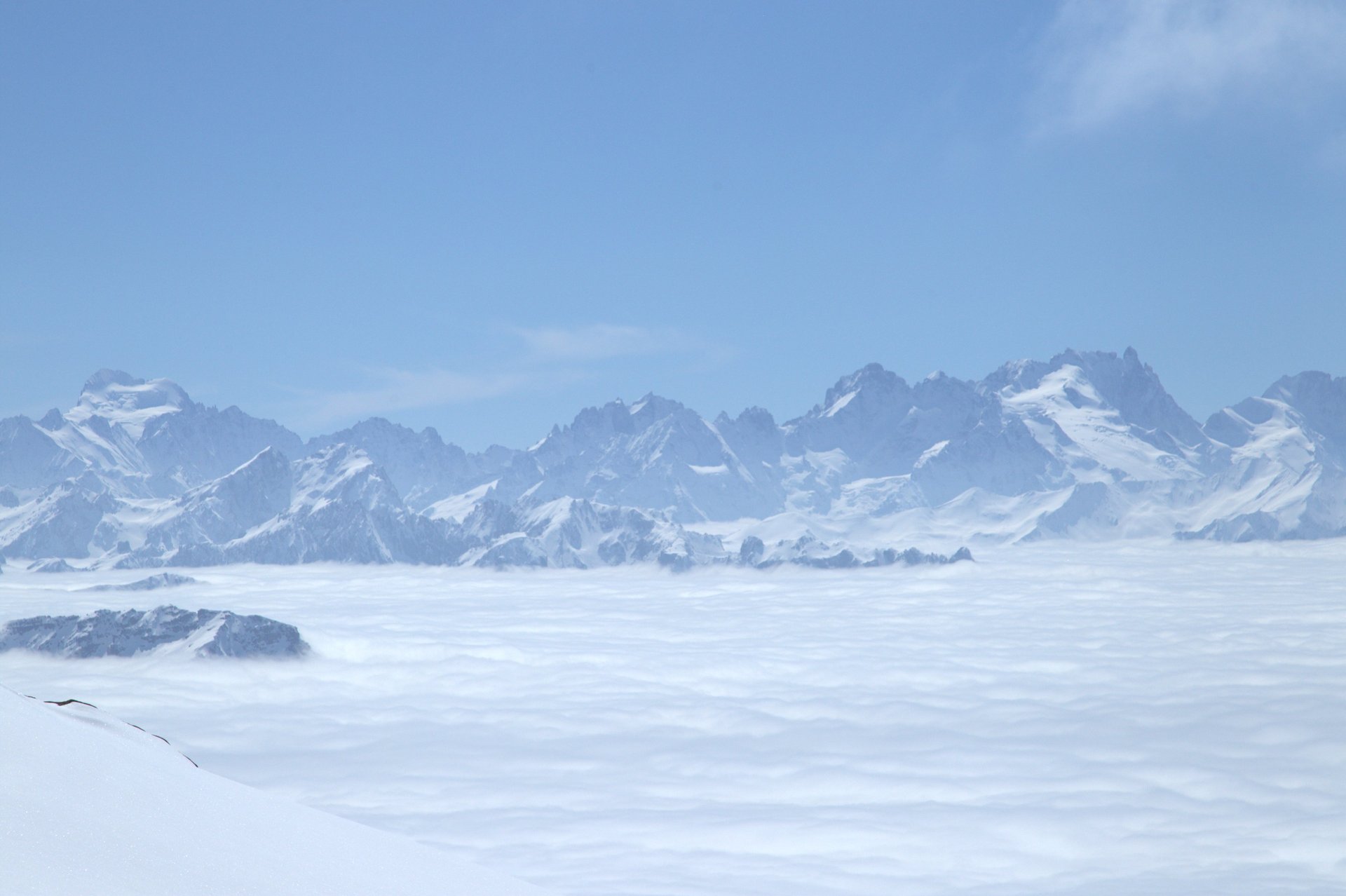 Snowy mountain panorama above the clouds in Val Thorens, French Alps, representing a peaceful alpine winter escape.