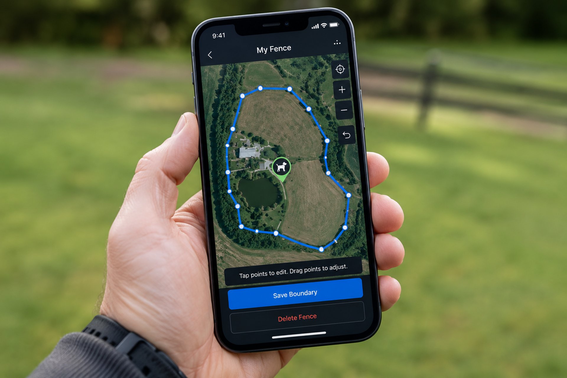 Hand holding smartphone displaying GPS boundary map for custom dog fence and property tracking.