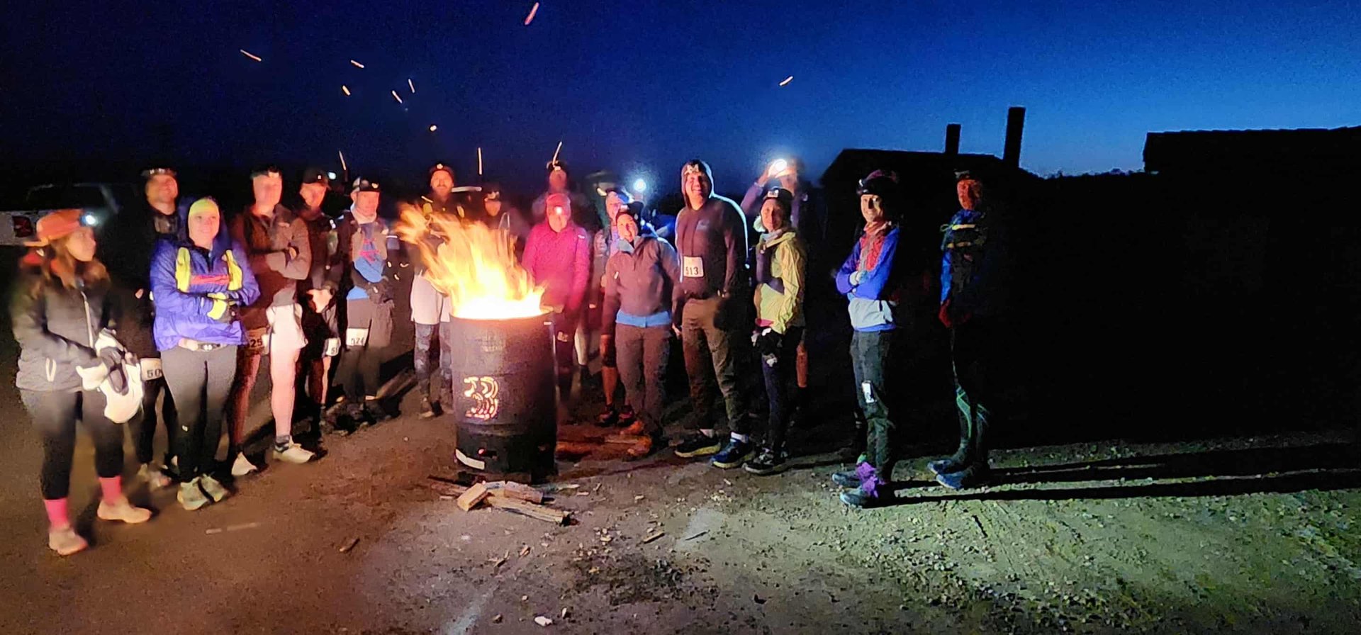 Runners prerace warming up in cool early morning before the race near the branded Spitfire Burn Barrels, Dusk scene