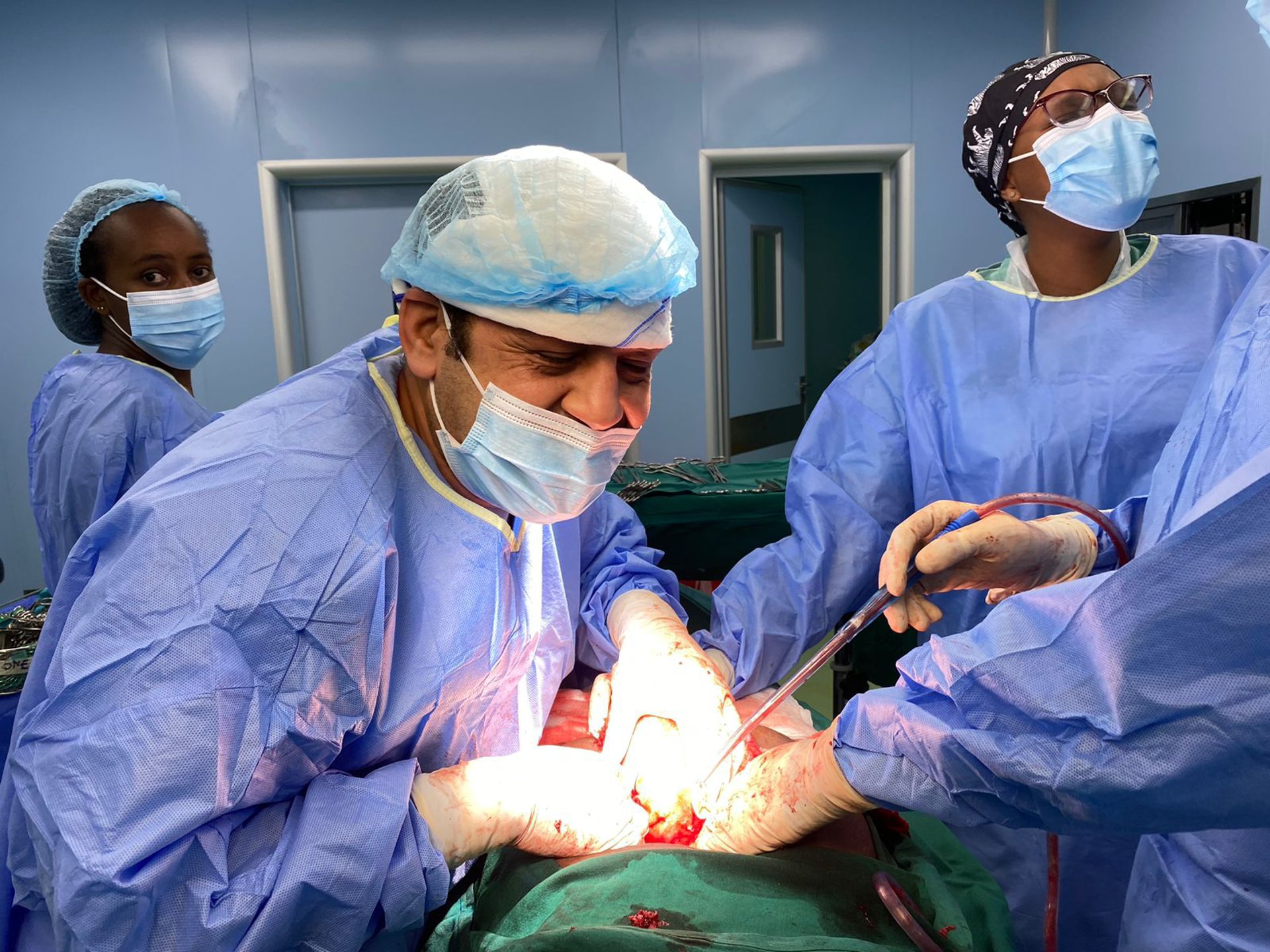 a group of doctors performing surgery on a baby
