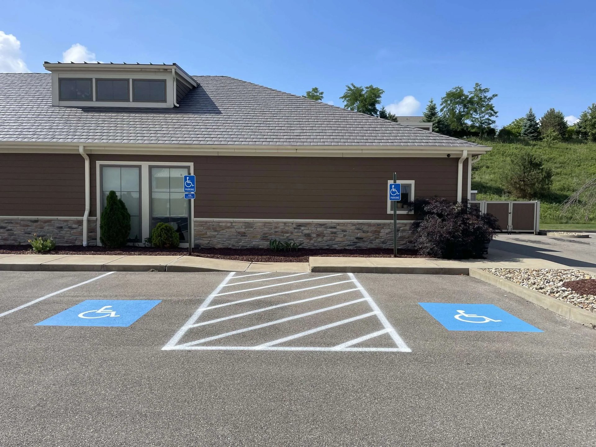 an empty parking lot with a blue sign on the side of a building