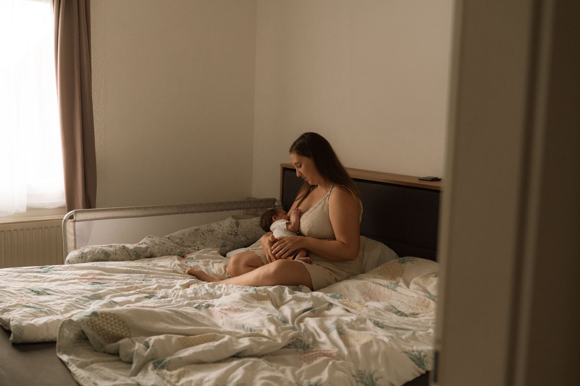 Mutter im bett mit baby gemütlich stillfotos Newbornshooting Babyfotos Fotograf in Wien Wiener Neustadt Sotrytelling motherho