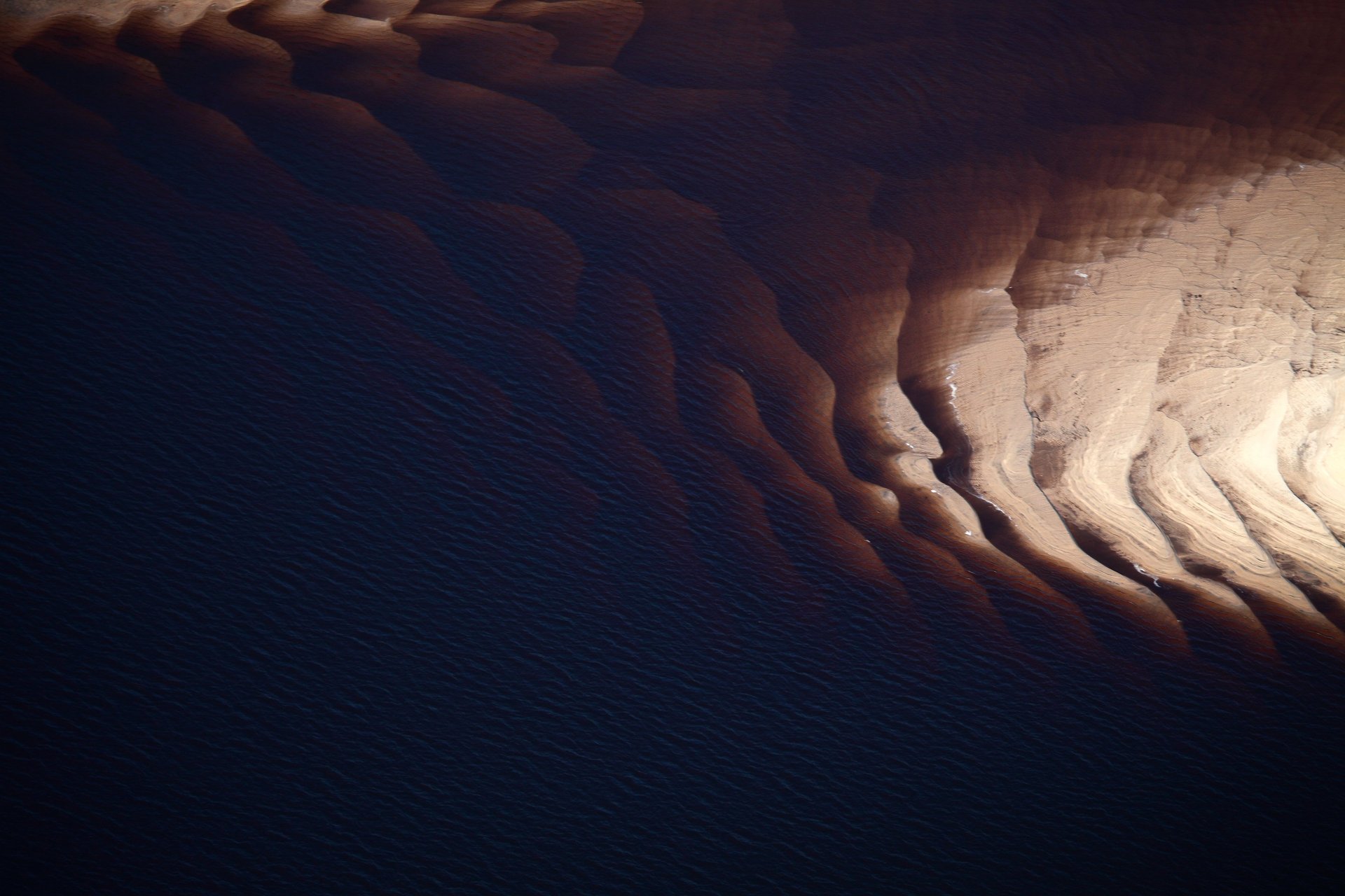an abstract photo of a curved building with a blue sky in the background