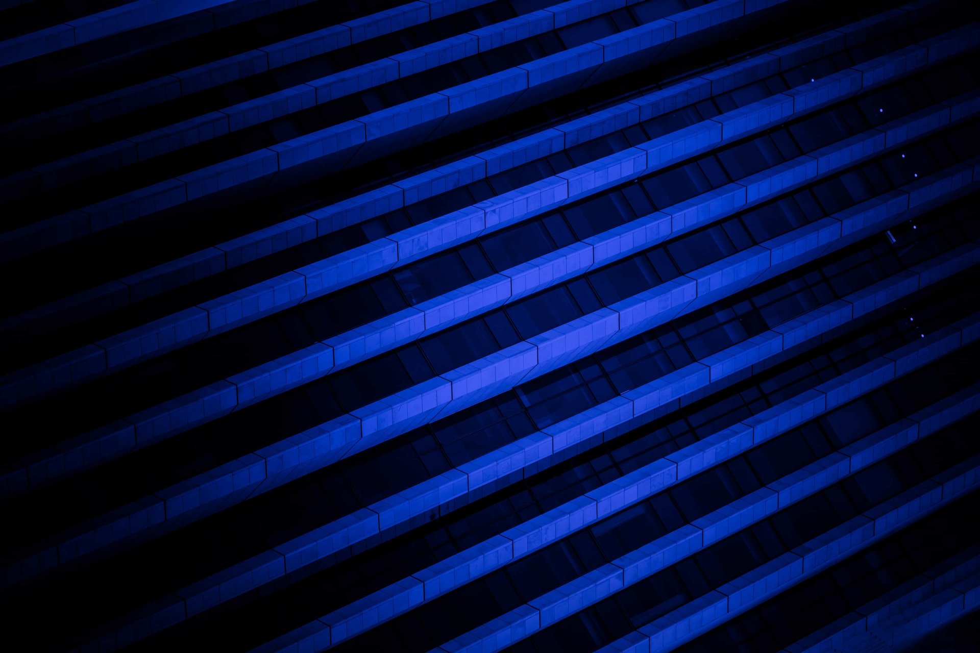 an abstract photo of a curved building with a blue sky in the background