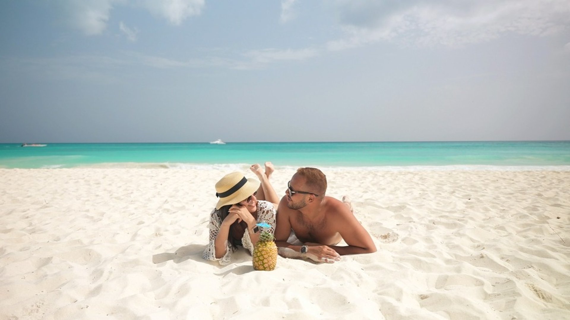 couple walking on beach during daytime