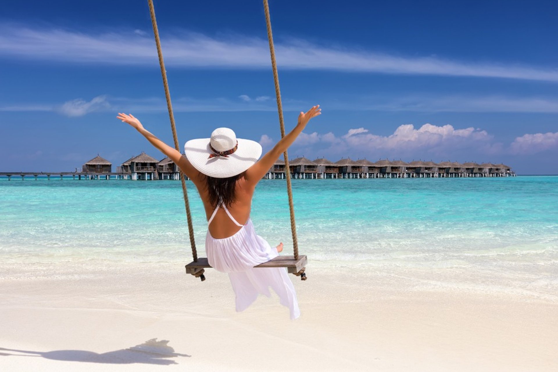 woman in white dress sitting on swing