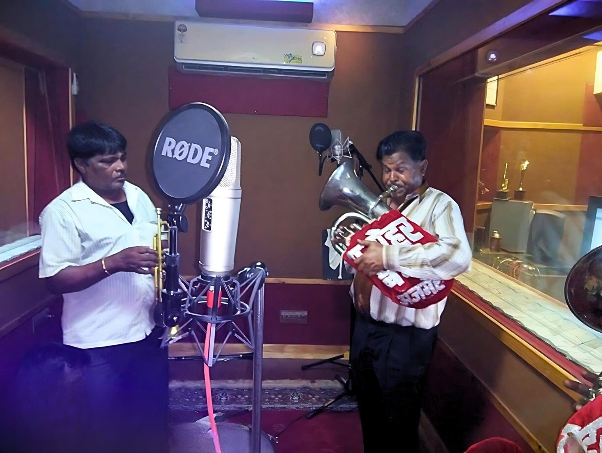 The Manohar Brass Band in a professional music recording studio, capturing their latest melodies.