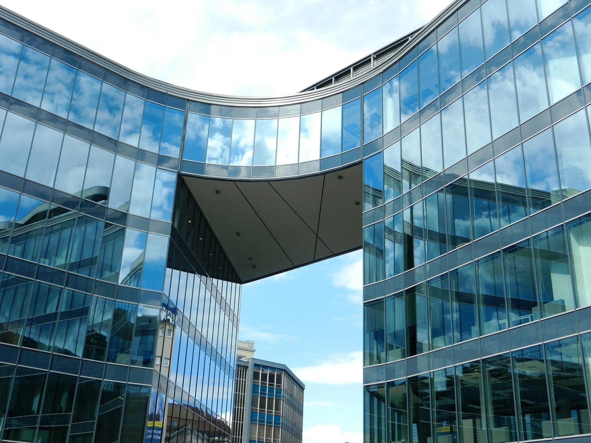 an abstract photo of a curved building with a blue sky in the background
