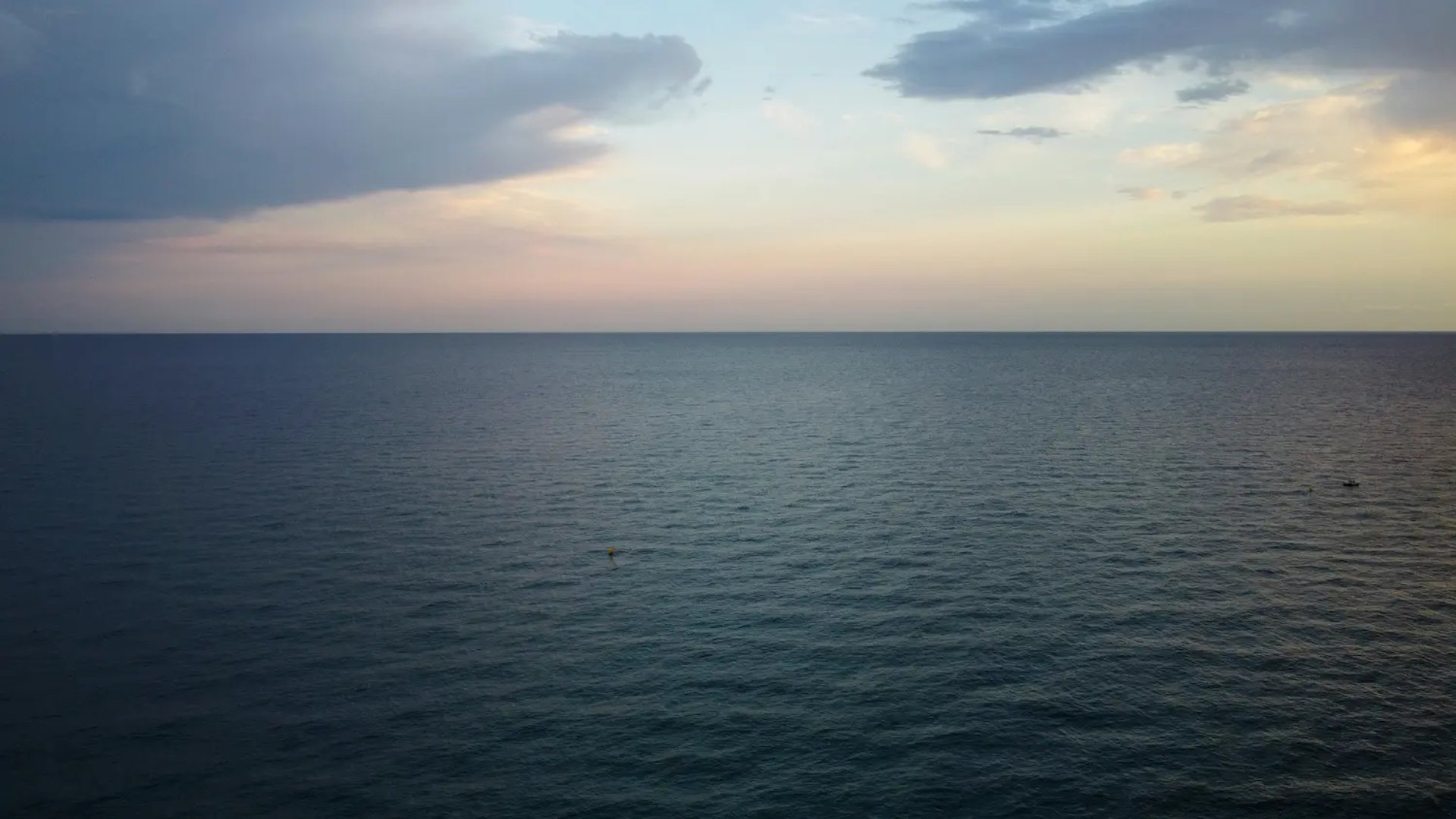 A sandy beach with a blue sky and ocean in the background