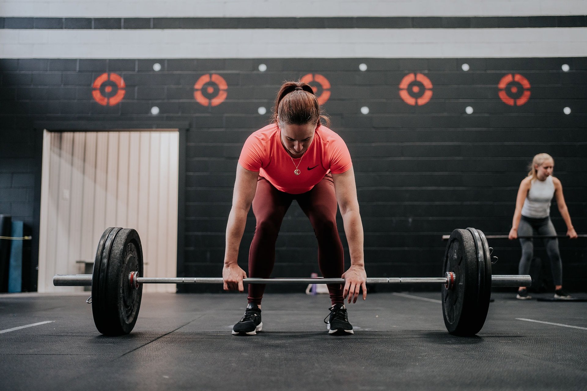 person locking gym plates on barbell