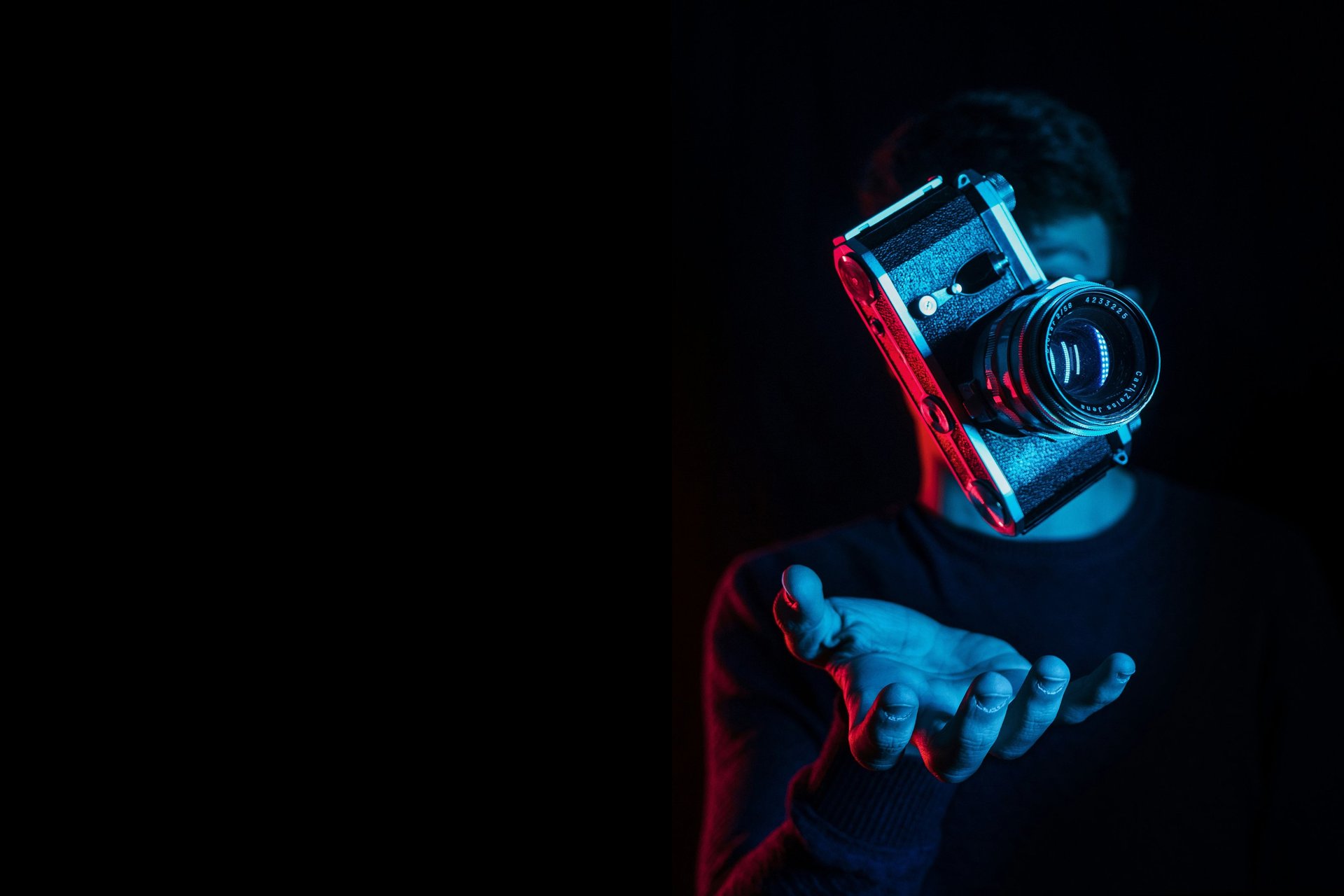 man in black hoodie holding black dslr camera