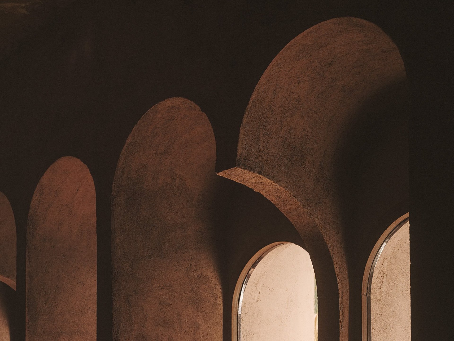 an abstract photo of a curved building with a blue sky in the background