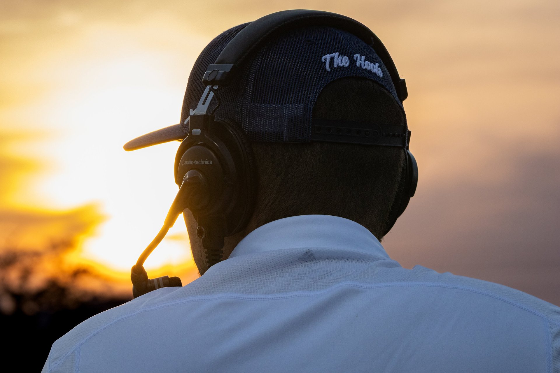 Broadcaster wearing headset with sunset in the background