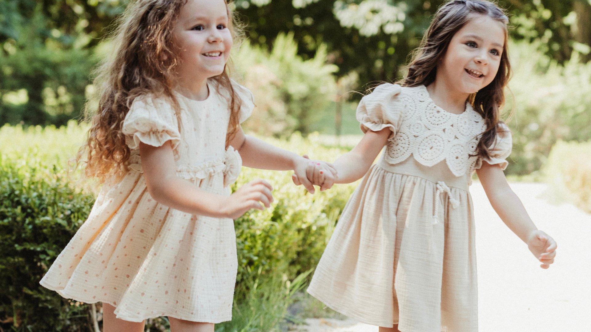 a little girl sitting on a blanket next to a teddy bear