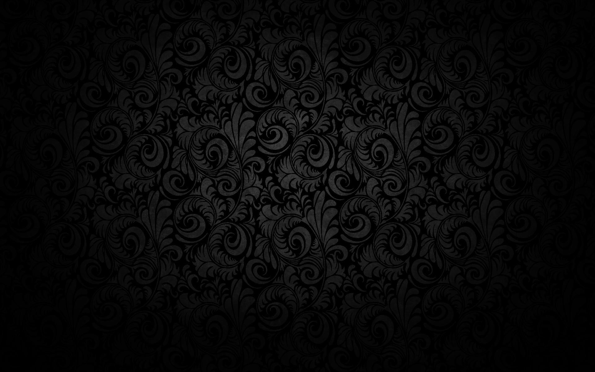 Black wallpaper featuring a leaf and swirl pattern which is highlighted by a faint spotlight