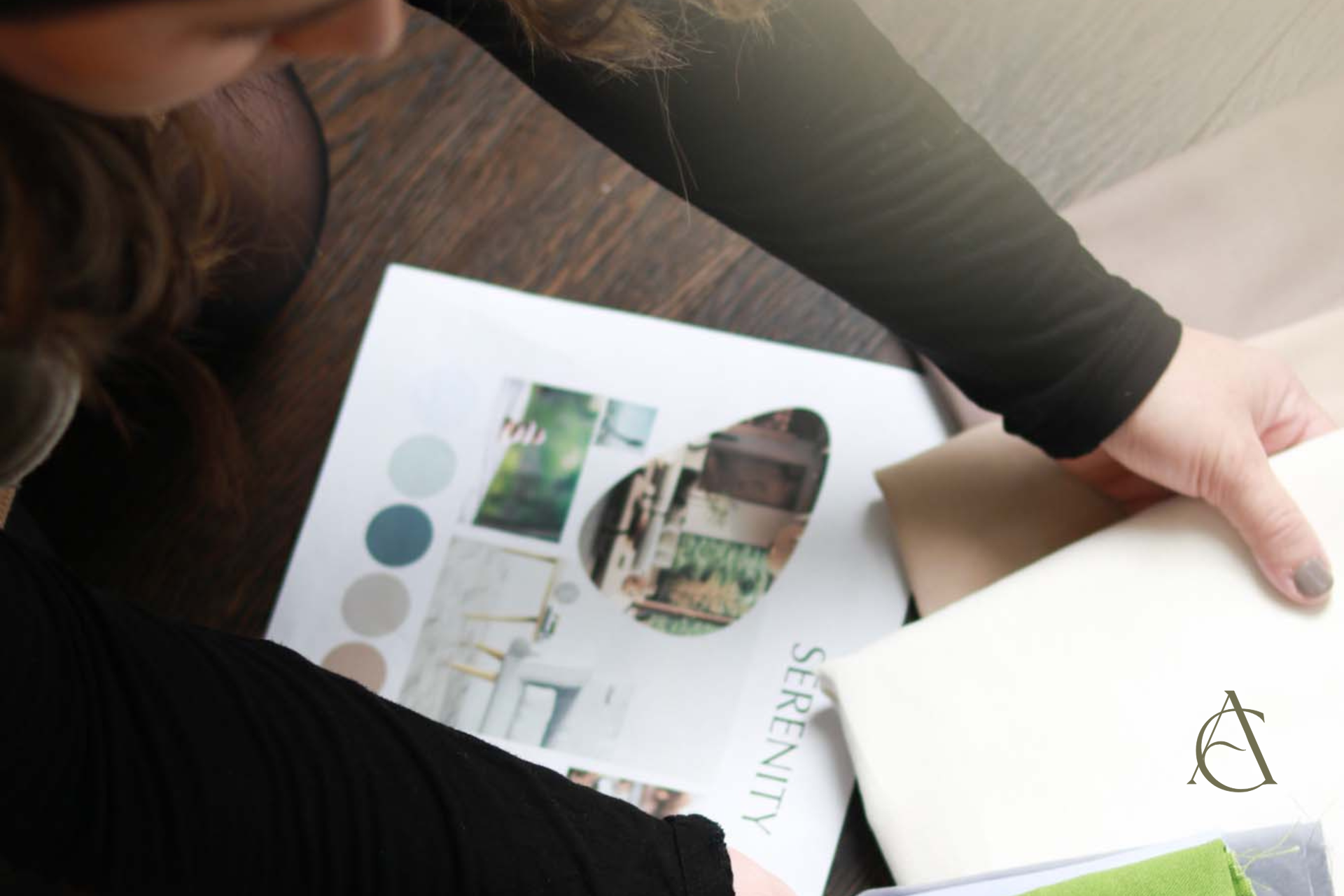 A designer selecting fabric swatches, with a "SERENITY" themed mood board providing color and visual direction.