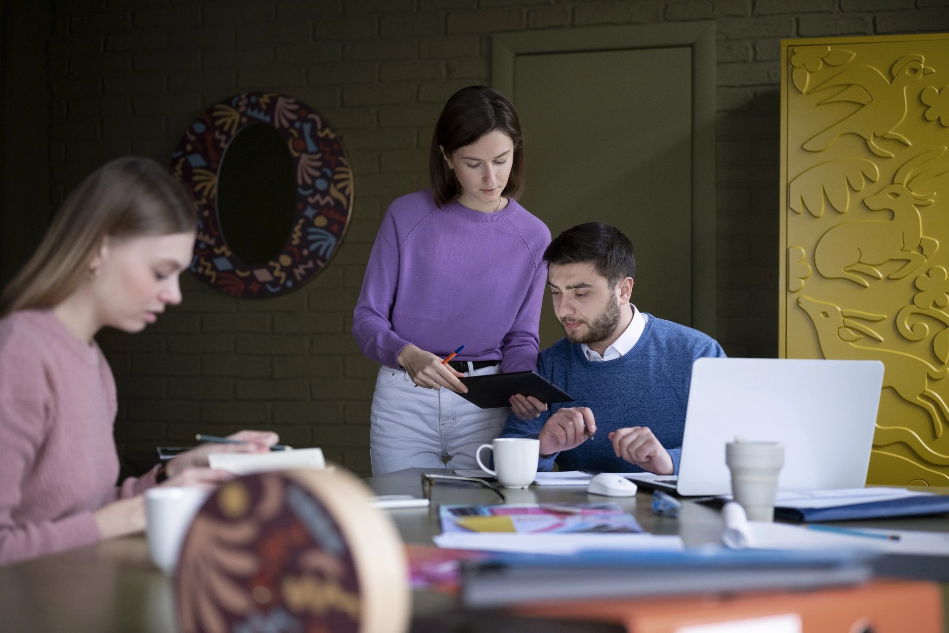 people sitting near table with laptop computer
