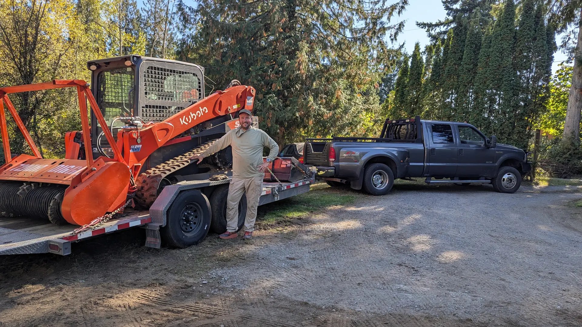 Owner operator in front of equipment and truck