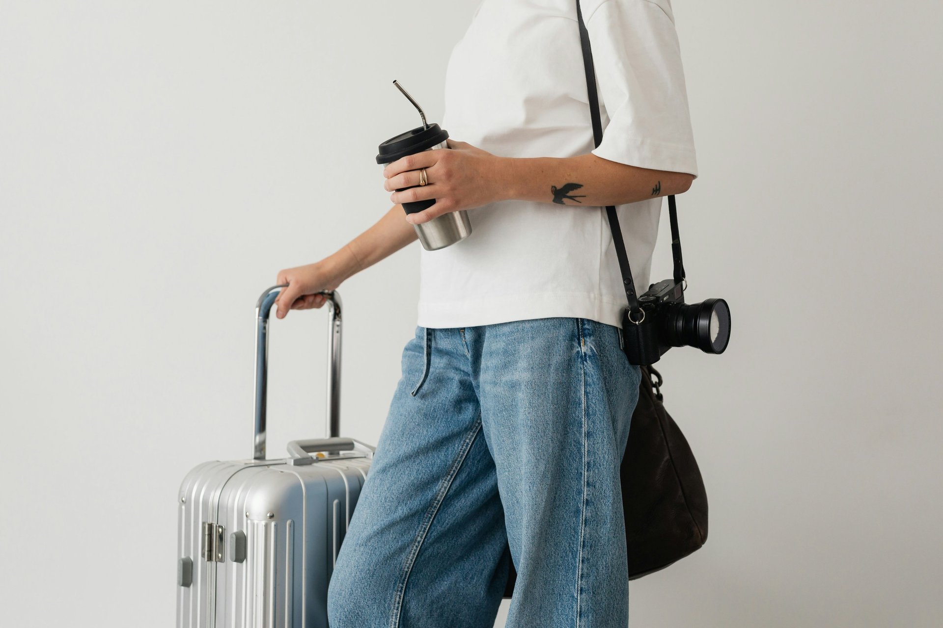 man in white shirt and black shorts standing on seashore during sunset