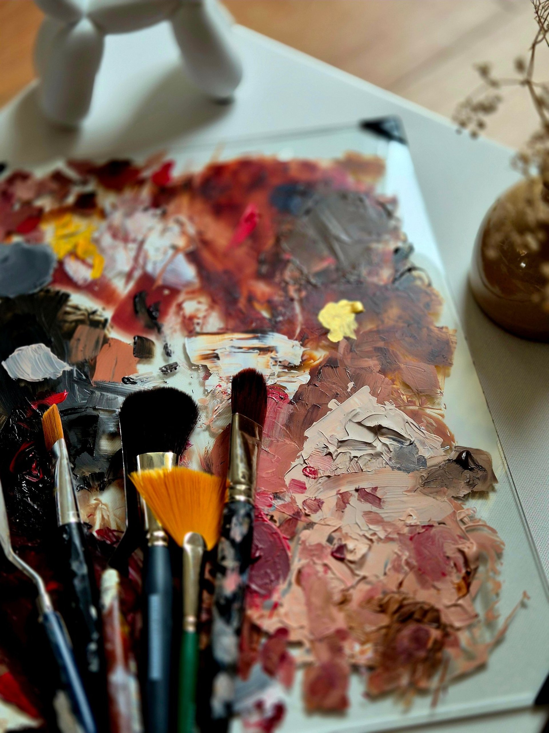 brown and red paint brush in clear glass container
