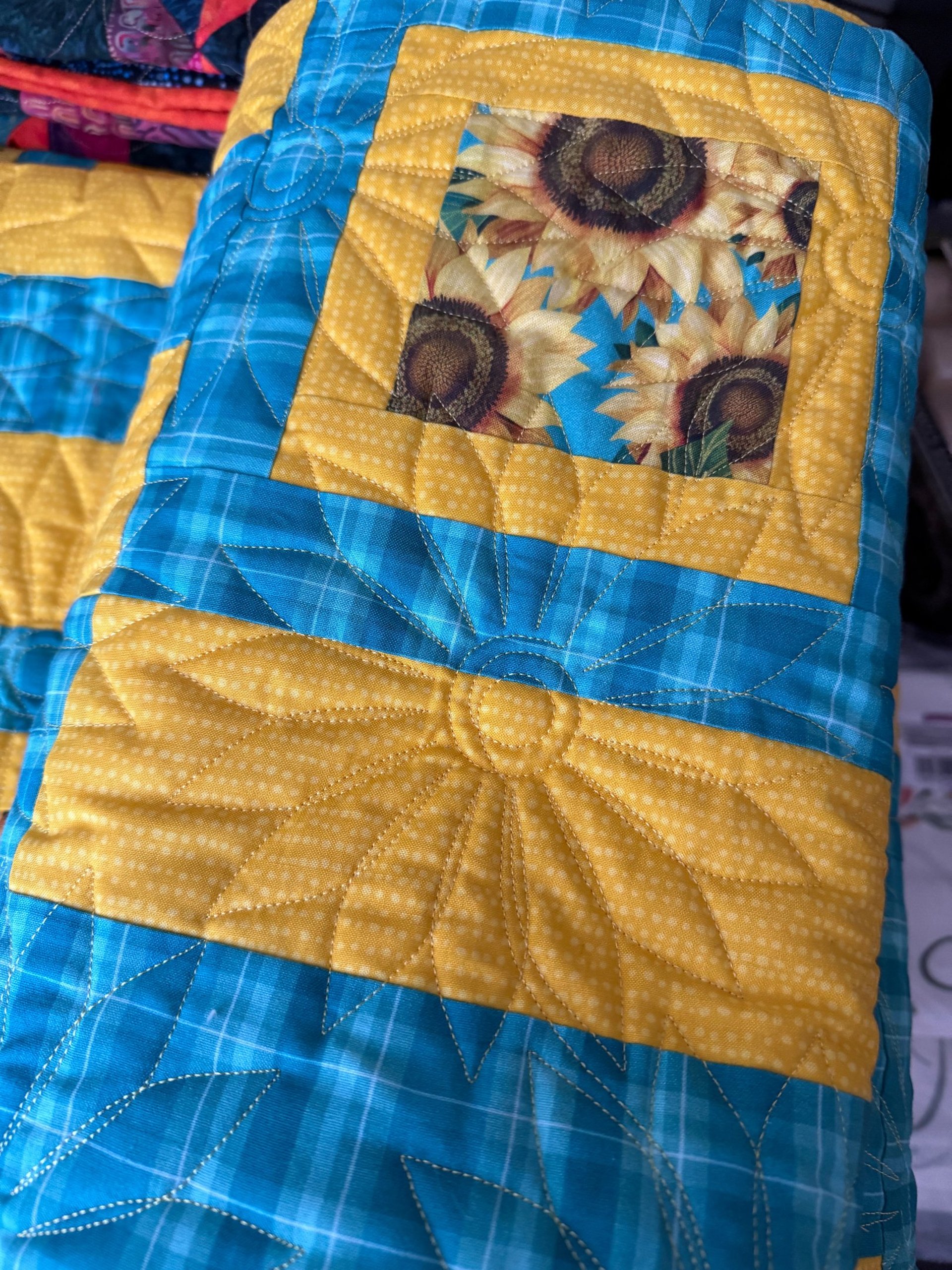 A quilt rests on a rustic wooden porch.