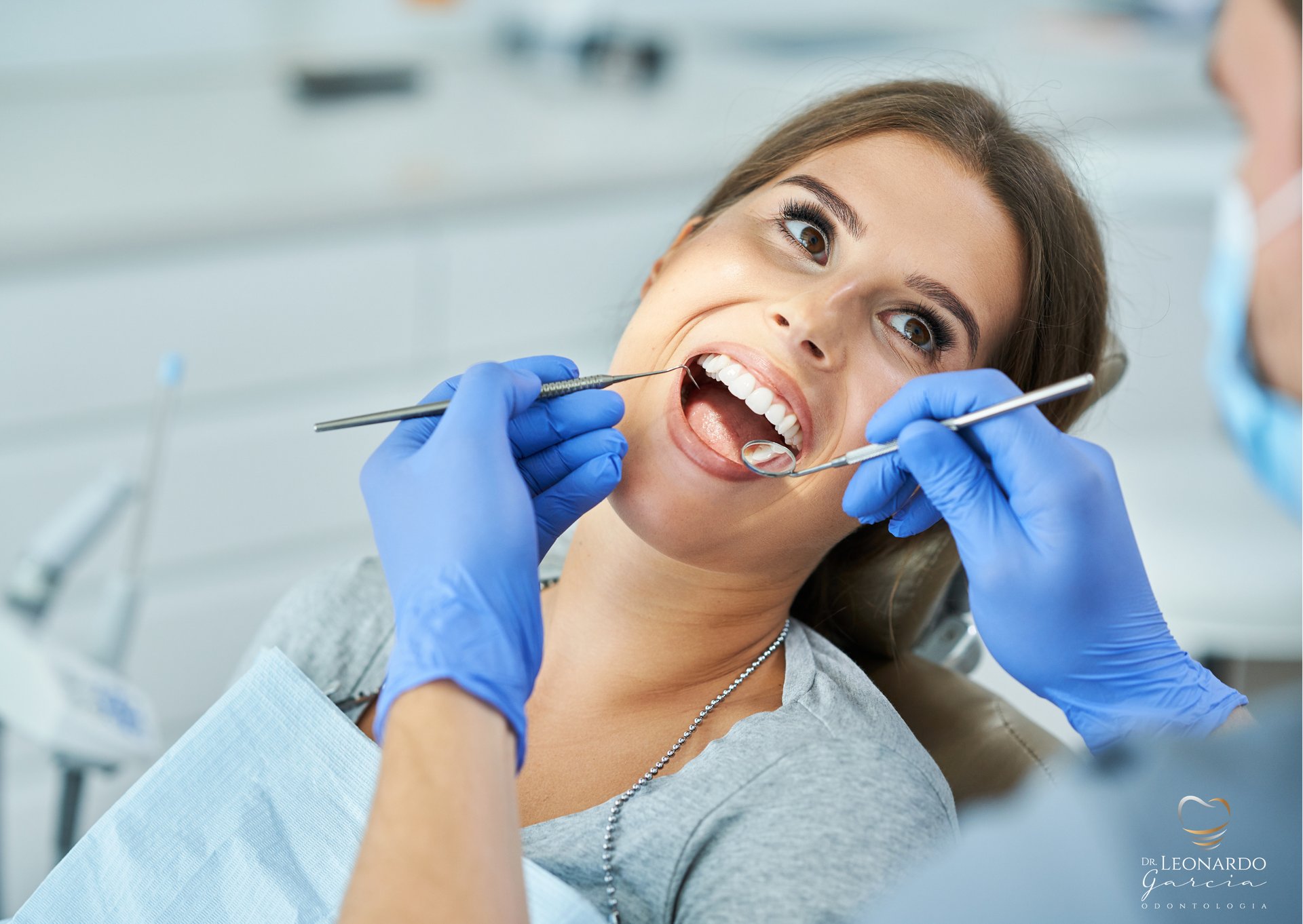 A dental room with a red chair and a sink