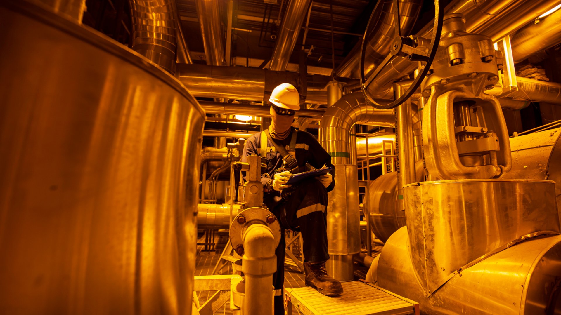 a man in a green coverall climbing up a yellow ladder