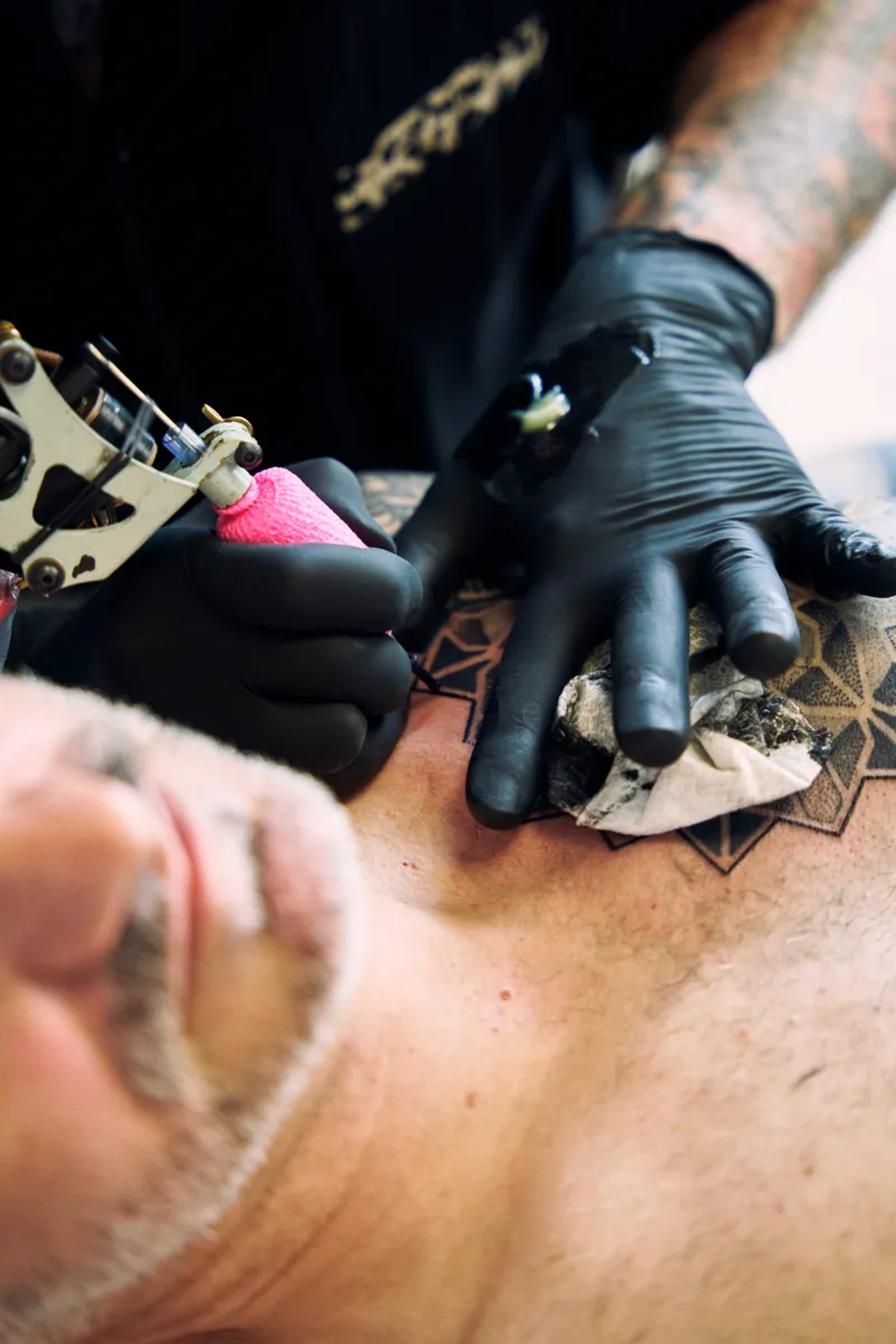 a man with tattoos on his arm holding a cigarette
