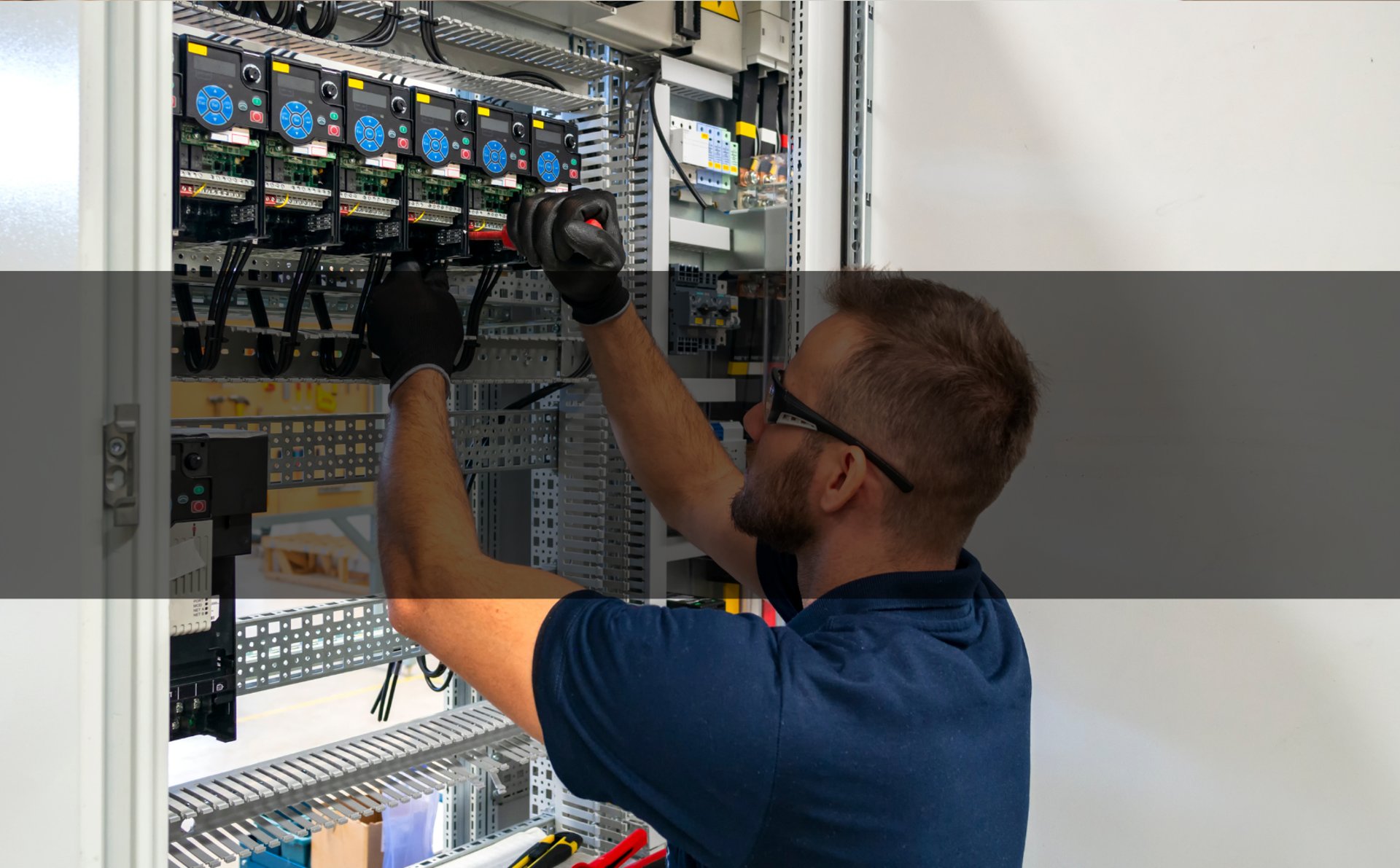  Homme en chemise bleue travaillant sur un cable d'alimentation avec bandeau noir