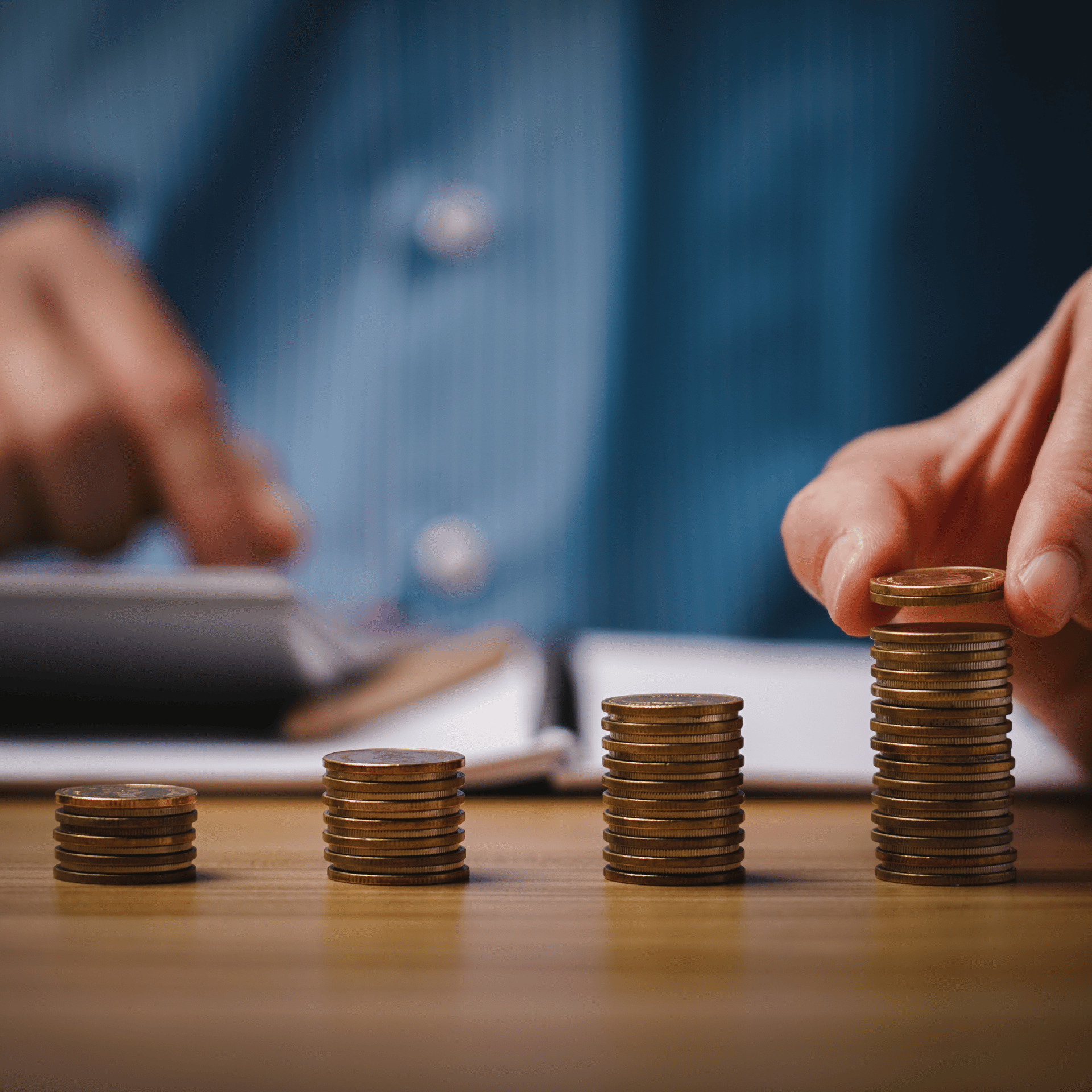 Une personne qui empile plusieurs pièces de monnaie