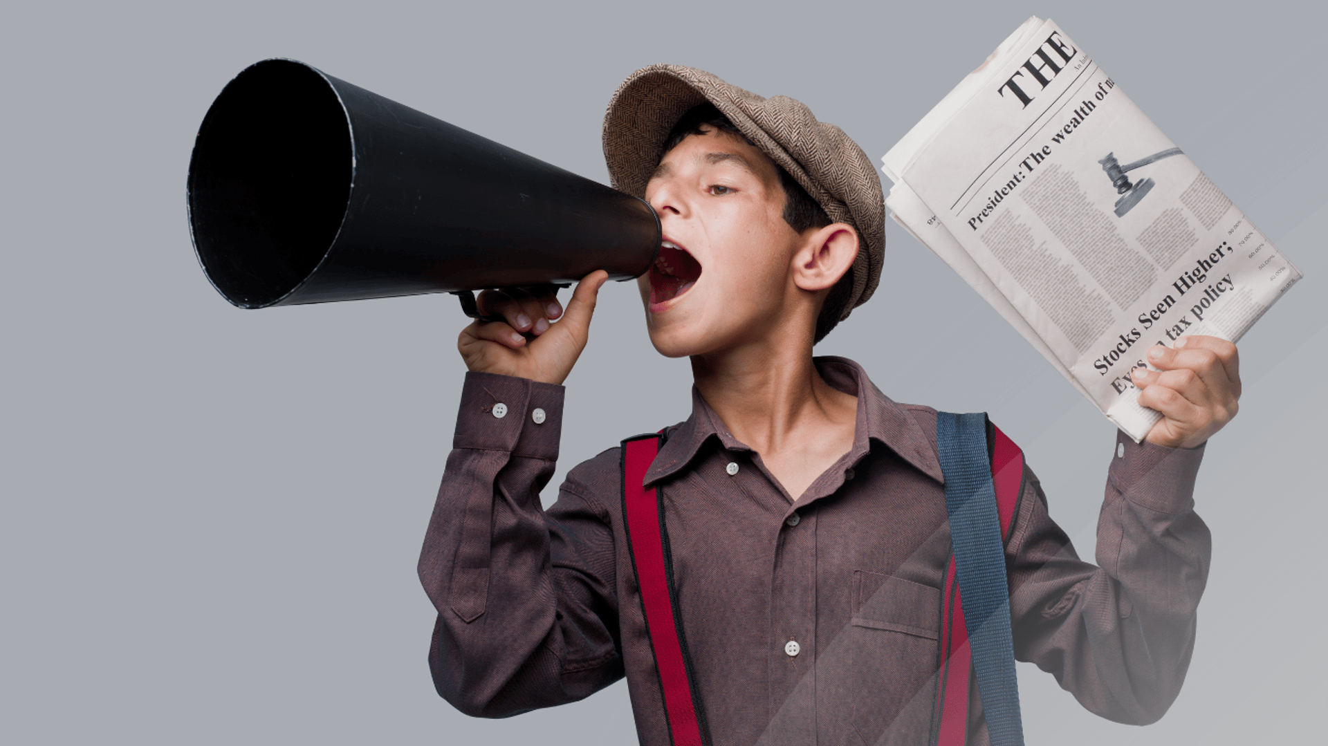 Enfant qui parle dans un microphone avec un journal à la main