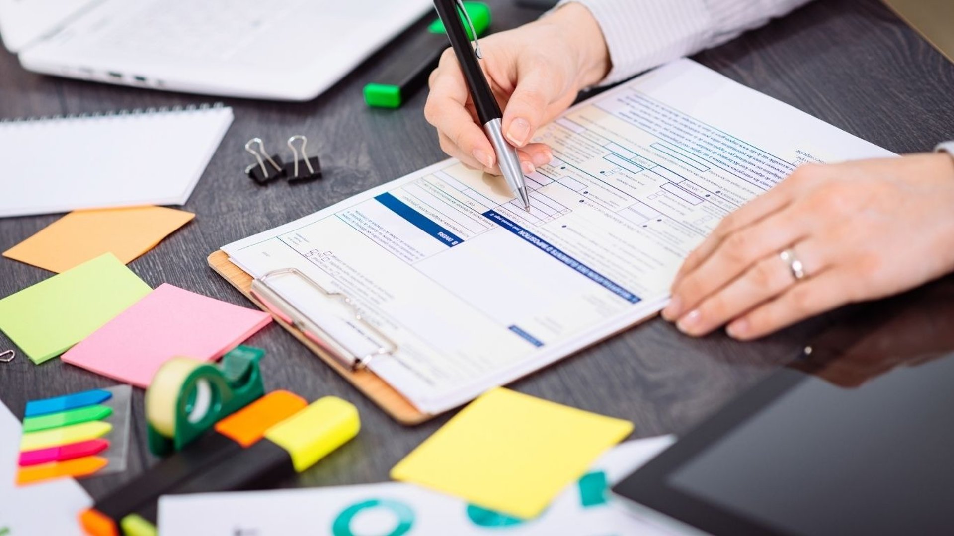 Une personne qui remplie une feuille avec un stylo