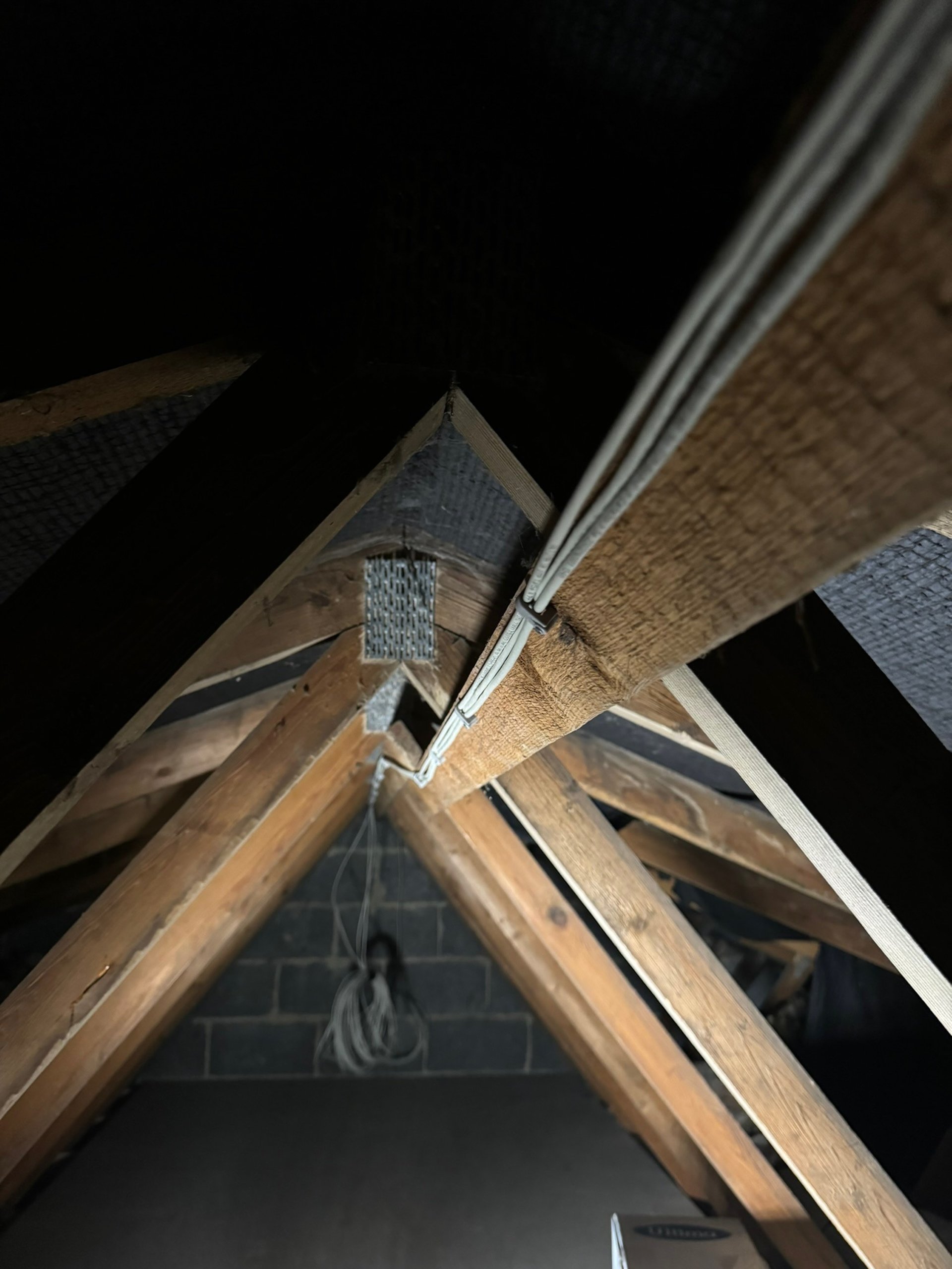 a black room with a white light coming from the ceiling