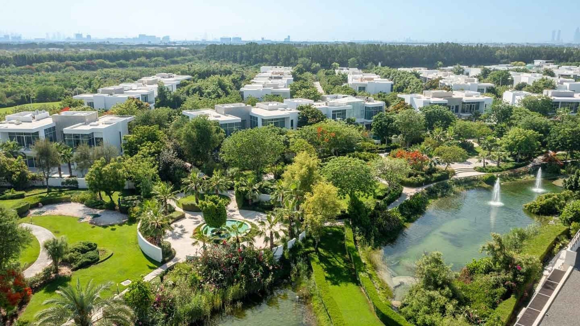 Aerial view of Al Barari Dubai showing landscaped gardens lakes and luxury villas within a low-density residential community