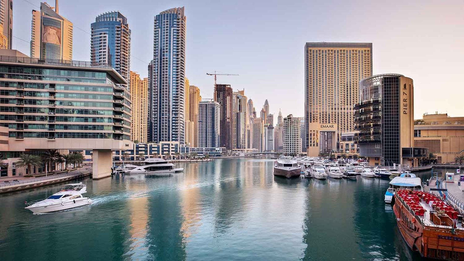Aerial view of Dubai Marina waterfront skyline with residential towers marina promenade and yachts in central Dubai