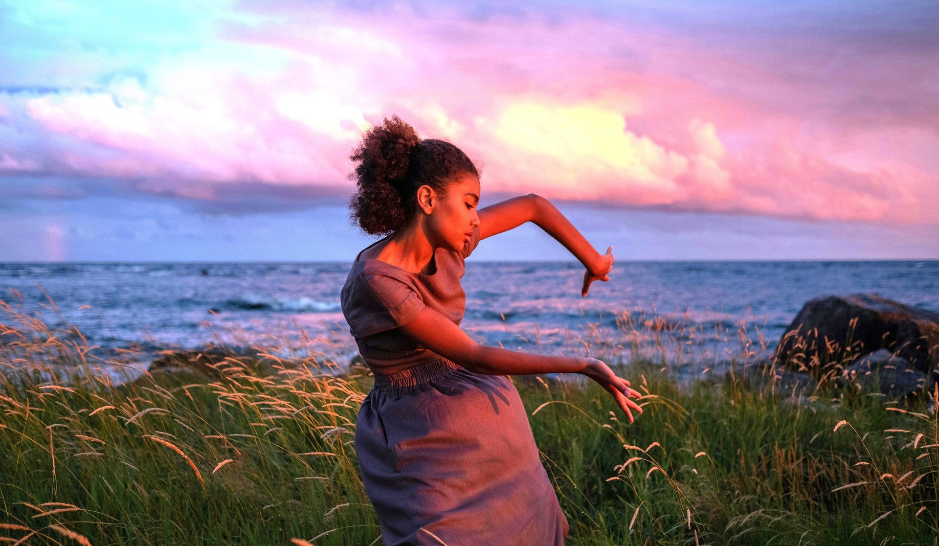 woman in black tank top with bag walking in seashore