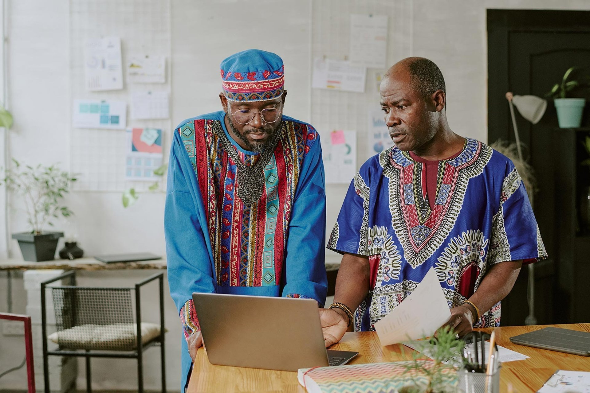 group of people sitting beside rectangular wooden table with laptops