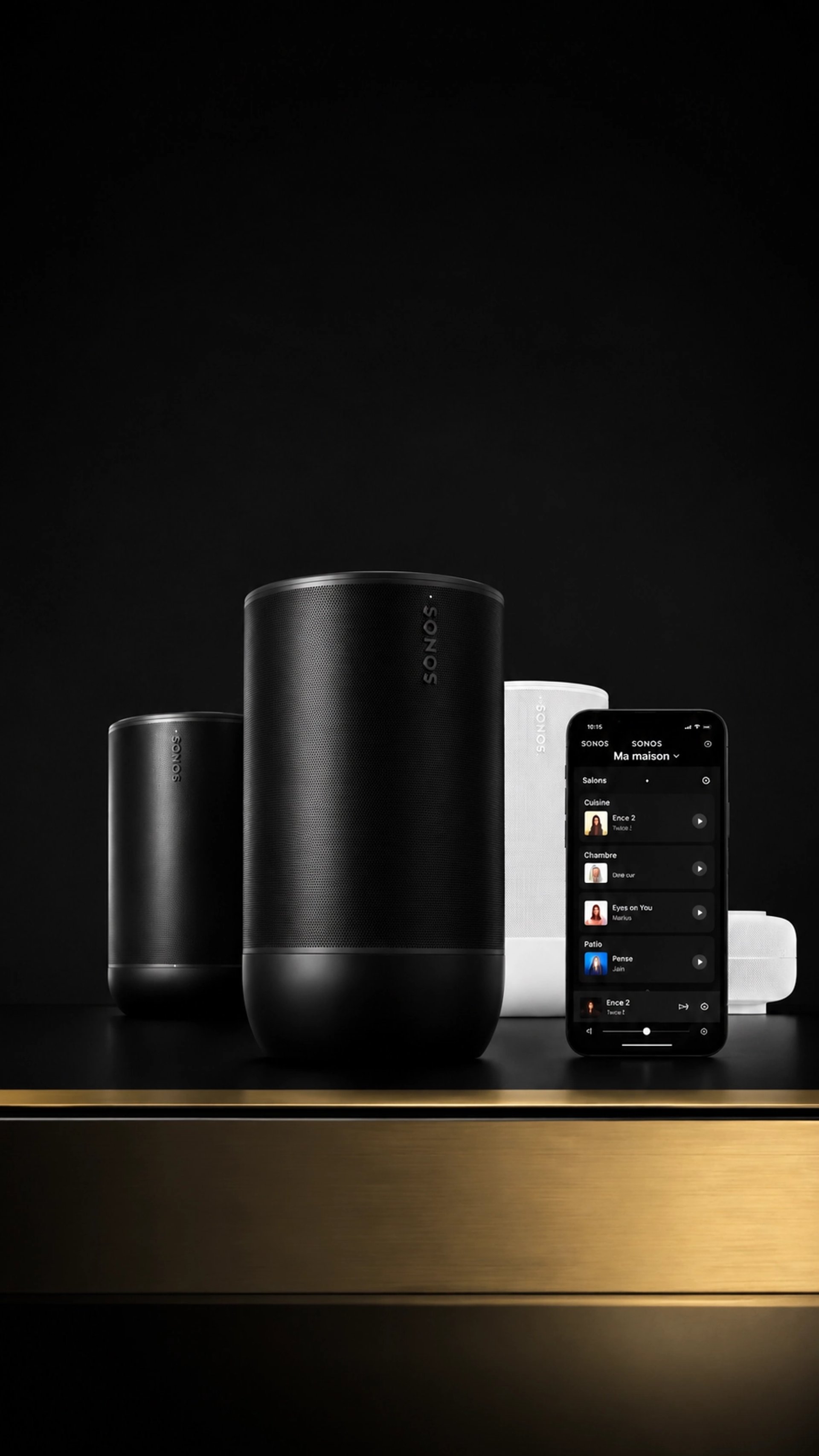Enceintes Sonos Move 2 noire et blanche avec smartphone sur un meuble au liseré doré, fond noir minimaliste.