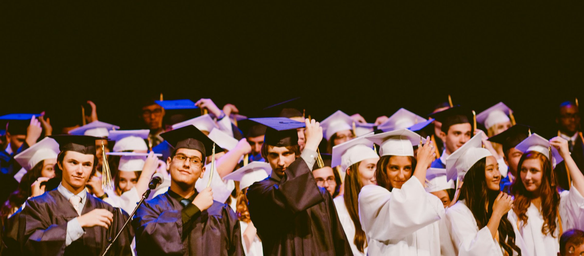 men and women wearing black and white graduation dress and mortar cap inside building