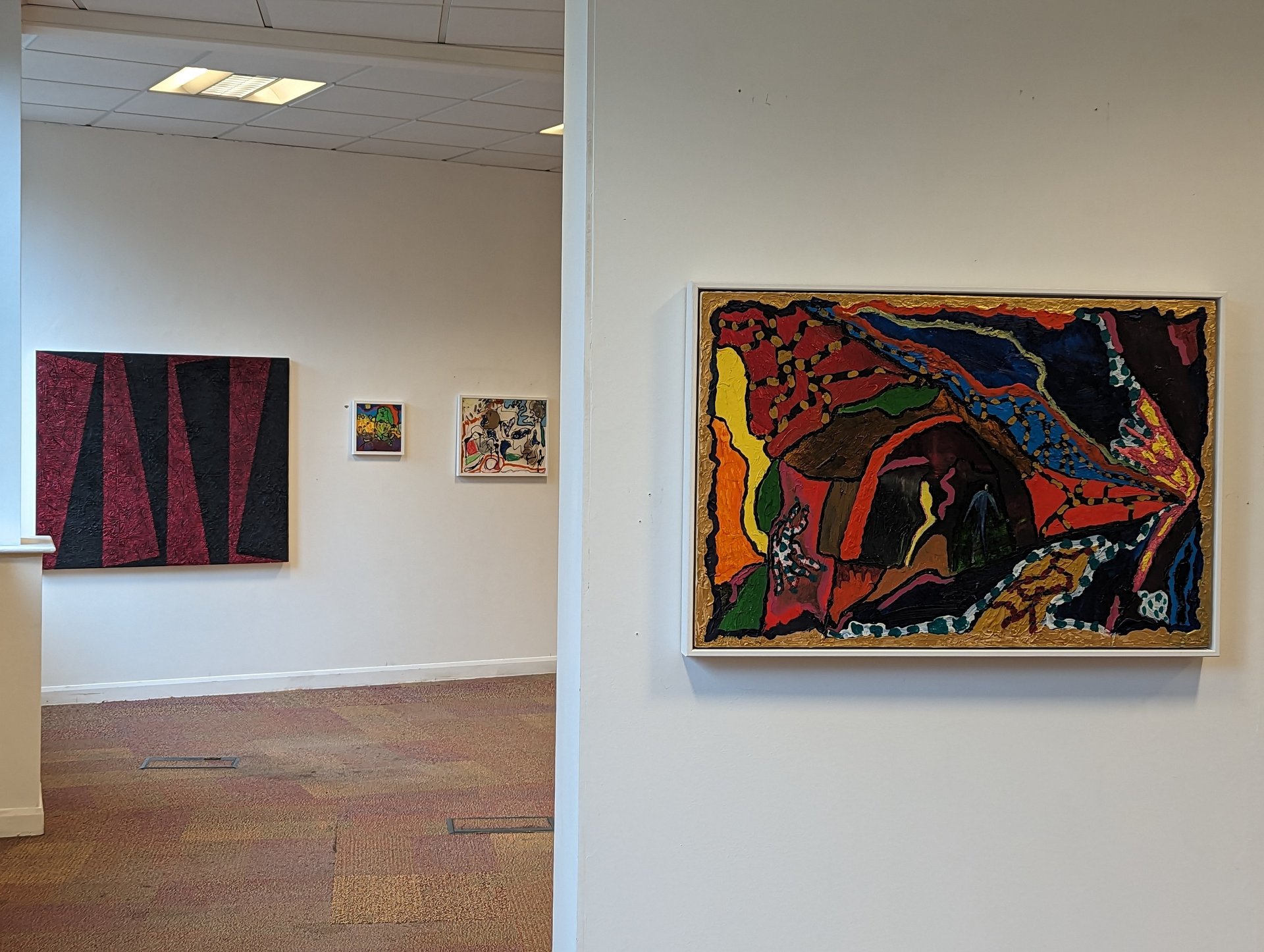 a woman looking at paintings on a wall