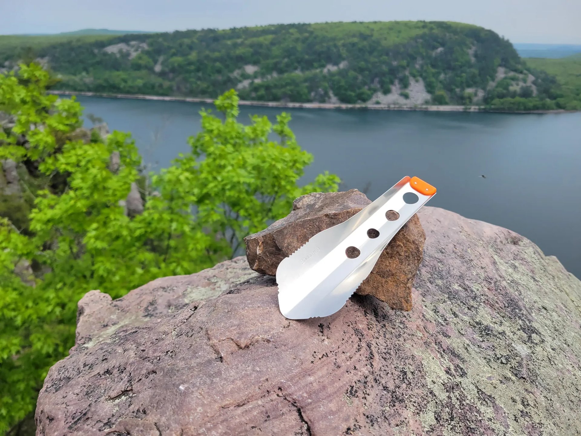 boglerco trowel lying on large rock in with lake behind