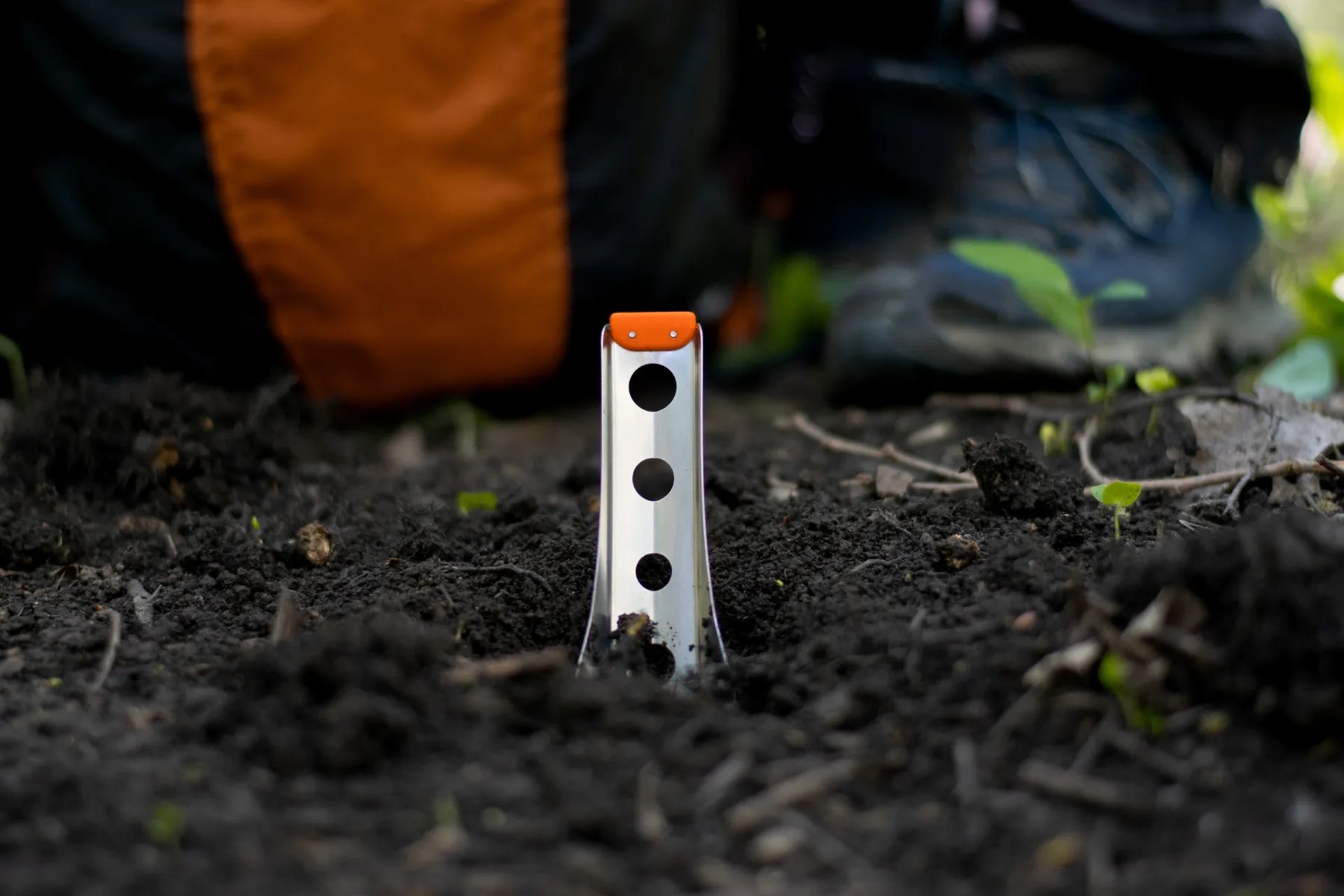 boglerco trowel stuck in ground with backpack and boots in background