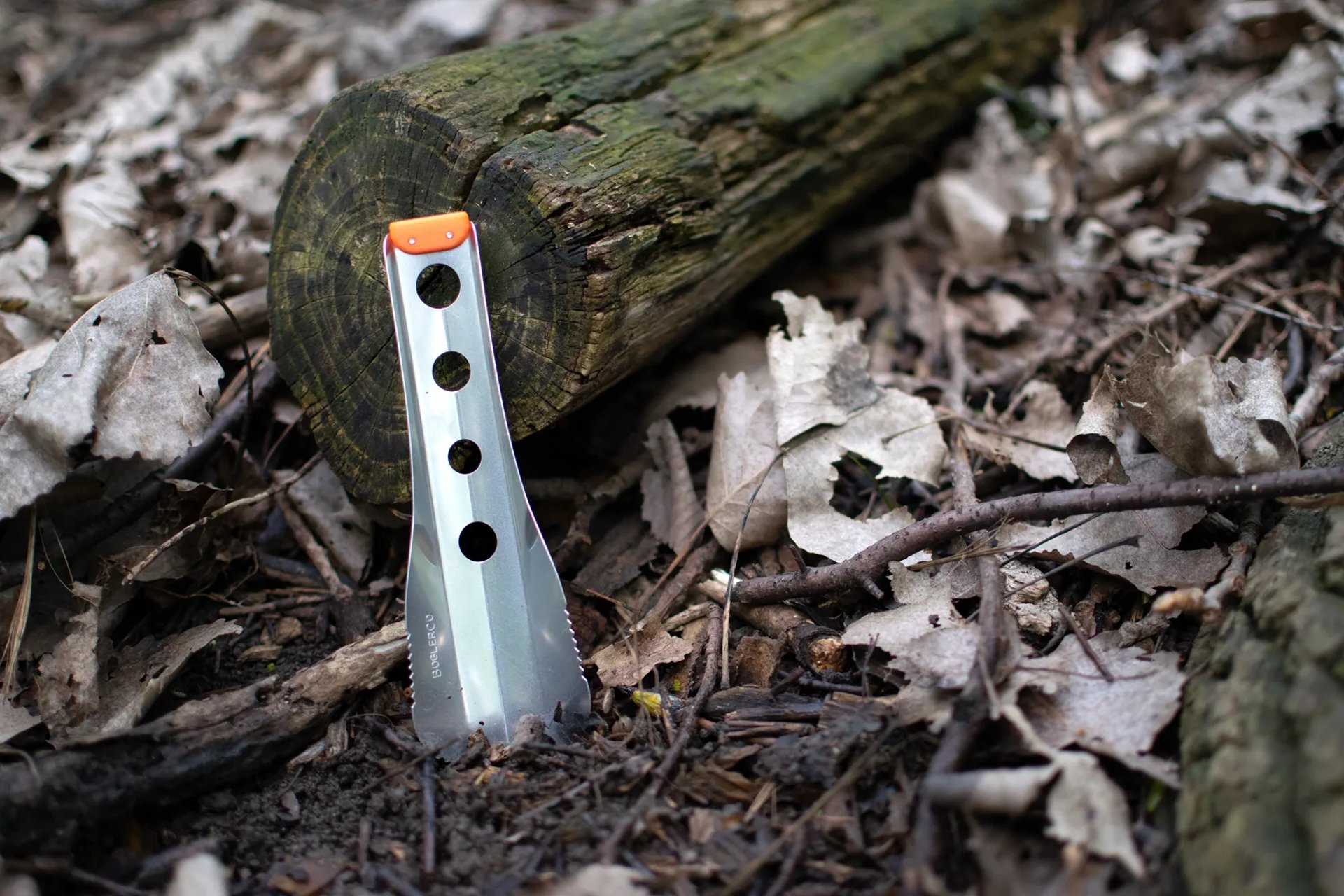 boglerco trowel propped against log on ground