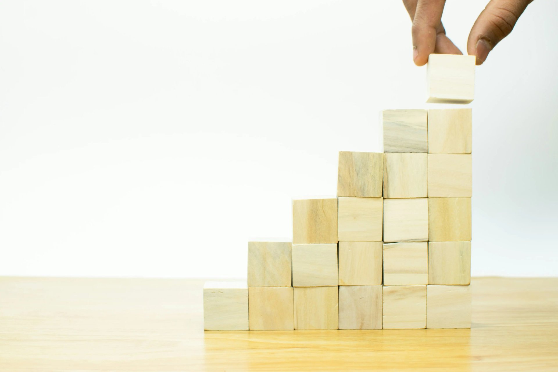 A person placing a piece of wood into a pyramid