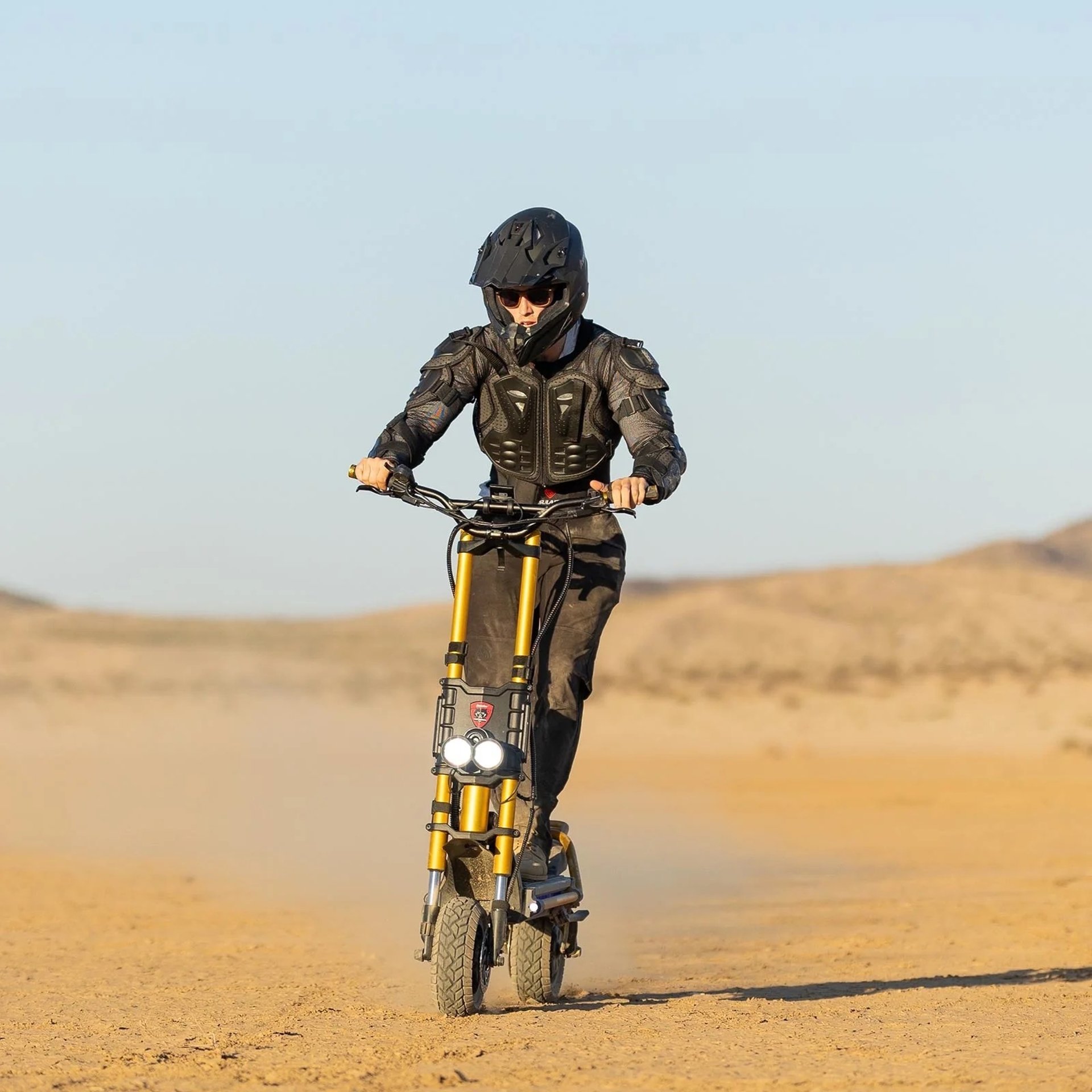 a man riding a scooter on top of a sandy beach