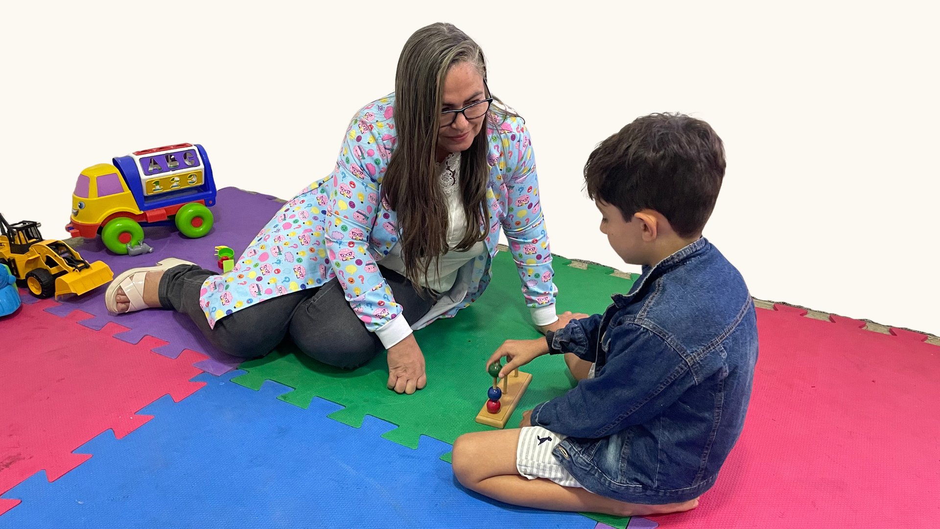 a little girl playing with a wooden toy